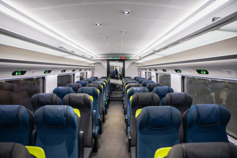 an empty train car with blue and yellow seats