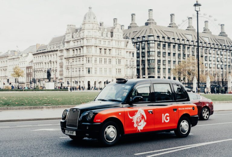 a red and black taxi cab driving down a street