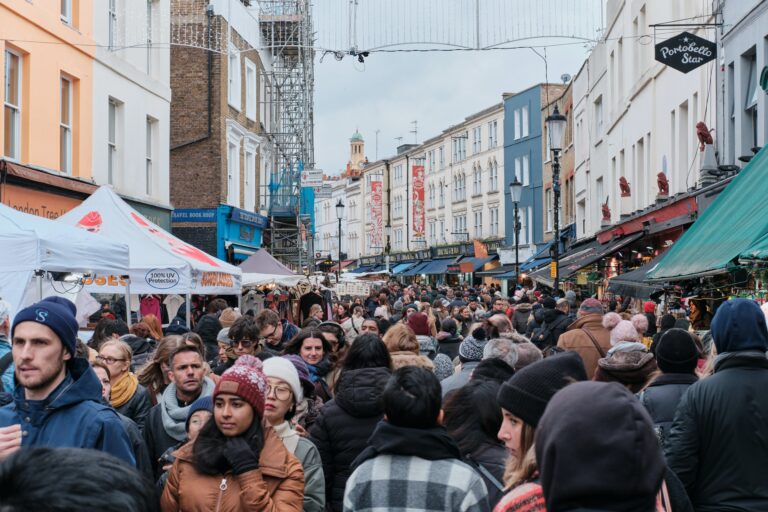 A throng of shoppers and city-dwellers fill up Portobello Market Road in London.